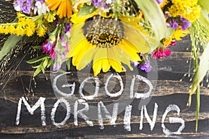 Words Good Morning with Summer Flowers on a Rustic Wooden Background