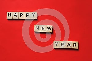 Words Happy New Year. Wooden blocks with inscription on red background. The bulletin board. Concept of holiday-Christmas and New