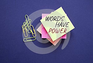 Words have power symbol. Yellow steaky note with paper clips with words Words have power. Beautiful deep blue background. Business
