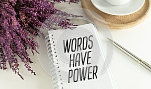 Words have power text on notepad on white office desk.