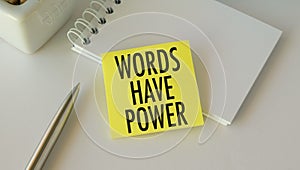 Words Have Power text on yellow sticky note with pen and notepad on white office desk, business concept