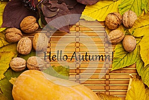 Words hello autumn on rustic background