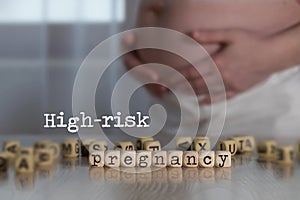 Words HIGH-RISK PREGNANCY composed of wooden letters photo