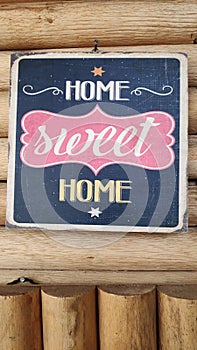 The words `Home Sweet Home` on the wooden boards