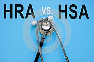 Words HRA vs HSA and stethoscope on the blue surface.