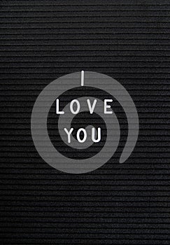 The words I Love You on black felt letter board