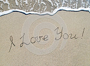 Words I love you outline on sand with wave brilliance