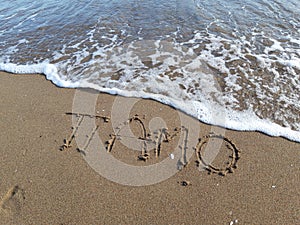 Words `I love you` written on wet sand at the sea