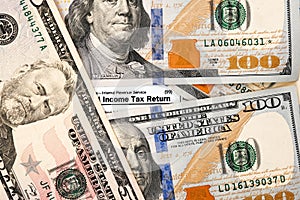 Words Income tax return on form 1040 and dollar bills close-up.