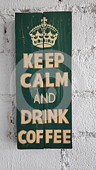 The words `Keep Calm and drink coffe` on the wooden boards