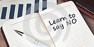 The words Learn to say no written on a white notebook. Work and study concept