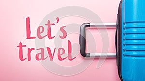 Words Let`s Travel Blue suitcase on pastel pink background Creative Summer holidays, vacation, travel concept Banner