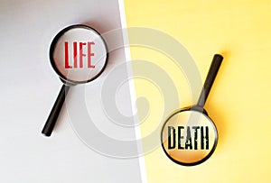 the words life and death in magnifying glasses