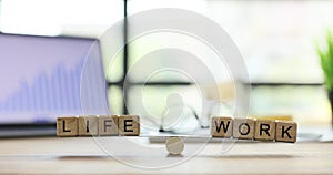 Words Life and Work from wooden blocks on toy scales