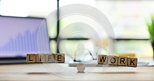 Words Life and Work written on wooden cubes balance on scales