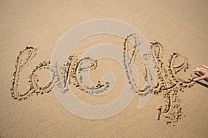 The words love life written in the sand