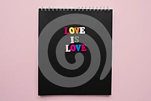 words love is love, notepad with chalk drawn heart. Valentine's day concept