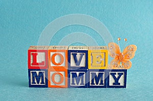 The words love mommy spelled with alphabet blocks