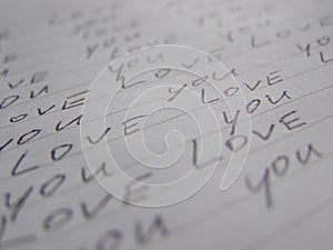 Words Love you written on lined white paper background. Perpective view photo