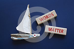 Words Matter symbol. Concept word Words Matter on wooden blocks. Beautiful deep blue background with boat. Business and Words