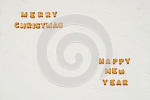 The words merry christmas and happy new year are written from cookie letters. Flat lay composition for greeting card