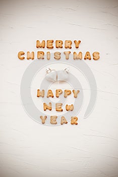 The words merry christmas and happy new year are written from cookie letters. Flat lay composition for greeting card