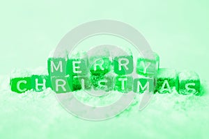 words merry christmas made of colorful blocks on pink background. green tone. Flat lay, top view - holidays, winter, christmas and