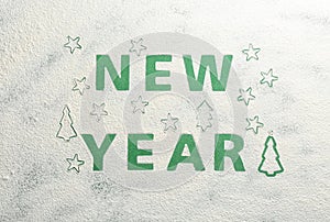 Words NEW YEAR made of flour on green background, top view