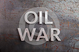 Words oil war laid with silver metal letters on rusted heavy hot rolled uncoated steel sheet surface - directly above