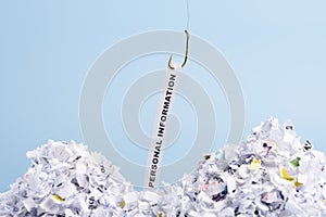 Words Personal information hooked on fishing hook pulled from pile of shredded documents on blue background