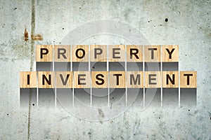 Words, Property Investment, consisting of letters on wooden cubes for construction on the background of an old concrete wall. Conc