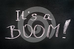 Words It\'s A BOOM! chalk written on blackboard
