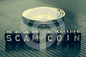 Words Scam coin made of black cubes on grey.