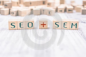 The Words SEO And SEM Formed By Wooden Blocks On A White Table photo