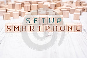 The Words Setup Smartphone Formed By Wooden Blocks On A White Table