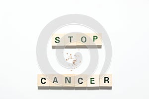 Words stop cancer made of wooden blocks and some tobacco isolated on white background