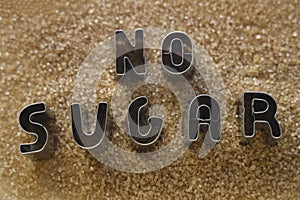 words stop eat made from metal letters. pile of cane brown sugar  on white background