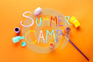 Words SUMMER CAMP, paints and brush on color background