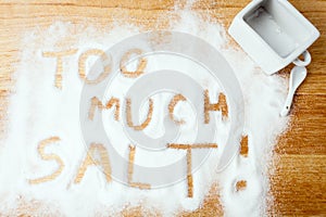 Words TOO MUCH SALT handwritten on salt