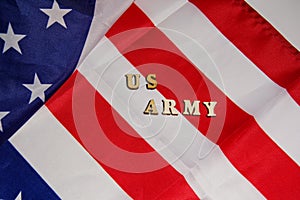 The words US Army written wooden letters on the USA flag background. American military power concept