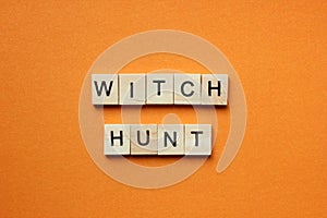 Words Witch Hunt. Wooden blocks with an inscription on an orange background. Bulletin board. The concept of the holiday is