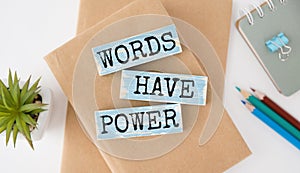The words Words Have Power written in 3d wooden alphabet letters isolated on an orange background