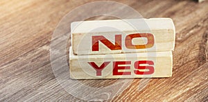 Words YES and NO on wooden blocks on wooden table. Decision making responsibility business concept