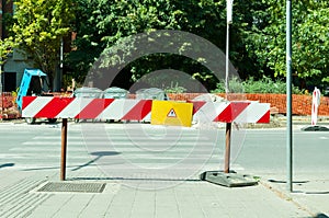 Work ahead street reconstruction site with sign and fence as road barricade