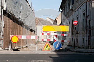 Work ahead street reconstruction site with sign and fence as road barricade