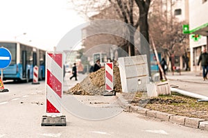 Work ahead street reconstruction site with sign and fence as road barricade