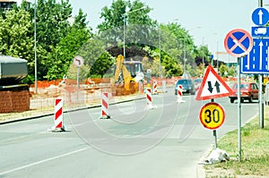 Work ahead street reconstruction site with sign and fence as road barricade