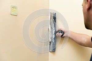 Work aligns - worker plastering wall with spatula