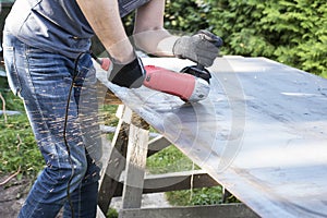 Work with angle grinder machine. Man is cutting metal