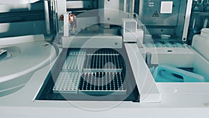 Work of the biochemical analyzer in the laboratory close up. test tubes that are automatically sent for examination